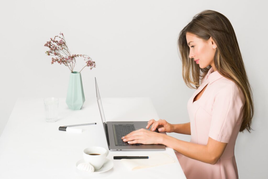 Lady learning on her laptop at a table
